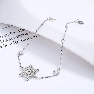 925 sterling silver snowflake bracelet with heart tag on elegant white surface