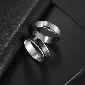 Pair of 6mm matte stainless steel spinner rings in silver and black colors for stress relief