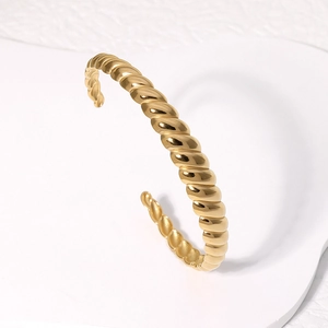 Twisted gold titanium steel open cuff bracelet with a minimalist French vintage design