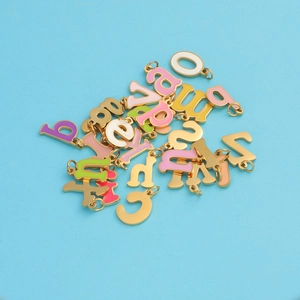 Colorful enamel letter A-Z pendants made of golden stainless steel on blue background