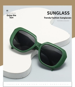 Close-up of green square frame sunglasses with polarized lenses on a white display pedestal