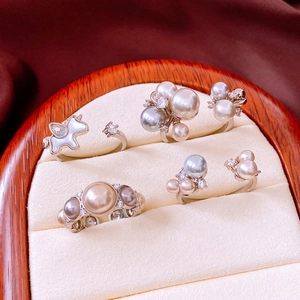 Detail of four vintage pearl rings with zircon in a velvet display box
