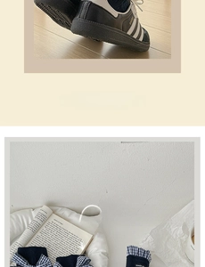 Close-up of navy blue Japanese style lace socks with bow details and black sneakers