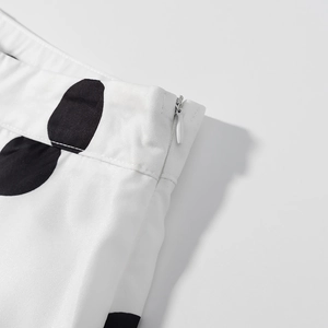 Détail de la fermeture éclair latérale sur le pantalon blanc à pois vintage