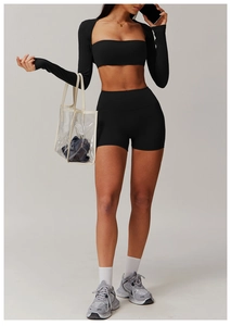 Close-up of high-waist yoga shorts and long sleeve cutout top in matte black stretch fabric