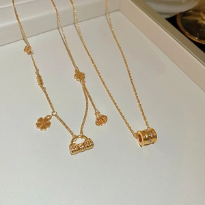 Detail of 18k gold plated flower lock and micro bag pendants on chic necklaces
