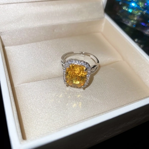 Macro detail of oval yellow zircon ring with silver multi-layer open band in jewelry box