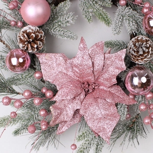Detail of pink poinsettia and frosted pine needles on a festive Barbie pink Christmas wreath