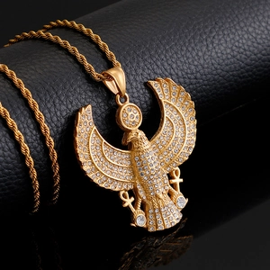 Macro shot of gold-plated eagle pendant with rhinestones on black leather surface