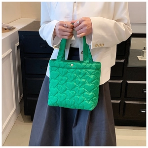 Detail of green heart quilted Oxford cloth handbag showing texture and soft fabric finish