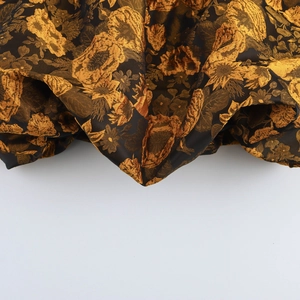Top corto jacquard dolce con motivi floreali dorati su tessuto nero lucido