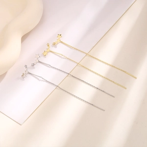 Detail of long chain earrings with gradient triple star design and sparkling zircon stones