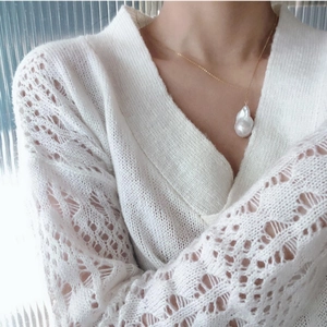 Elegant baroque freshwater pearl pendant necklace on a gold chain worn with white knitwear