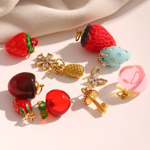 Détail de breloques fruits et fleurs dorées 18 carats avec zircons et résine colorée