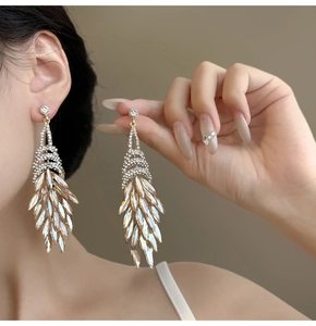 Macro shot of elegant champagne gold leaf fringe earrings with brilliant rhinestones