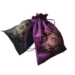 Detail of purple and black velvet drawstring pouches with gold sacred geometry patterns