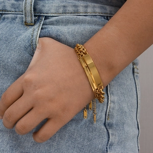 Close-up of a 18K gold-plated cuban link bracelet with a polished metal plate on a wrist