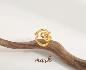 Detail of twisted spiral 18K gold plated ring on a rustic wood background