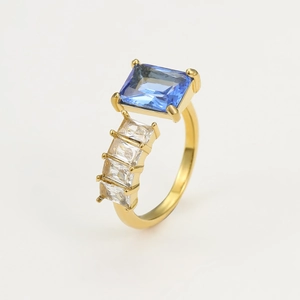 Detailed macro view of gold-plated ring with large blue zircon and white gemstone accents