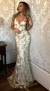 Close-up of elegant white sequin mermaid dress with gold shimmering details