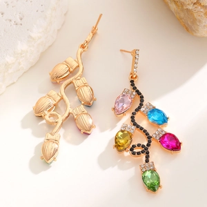 Gros plan sur des boucles d'oreilles dorées avec cristaux colorés en forme de poire
