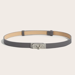 Detail of grey slim leather belt with sparkling rhinestone lock buckle on white background