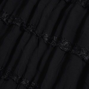 Close-up of black pleated fabric dress featuring delicate lace trim and fine textures