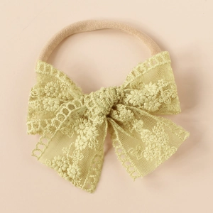 Detailed view of yellow embroidered lace bow on high-elastic nylon baby headband