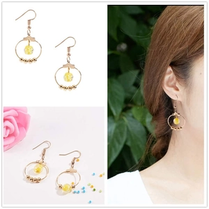 Gold round hoop earrings with yellow beads shown on model and white background