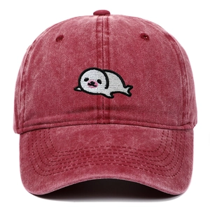 Detailed embroidery of a white seal on a vintage washed burgundy cotton baseball cap
