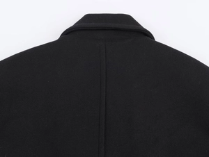 Close-up of the back neckline and shoulder stitching on a black woolen coat