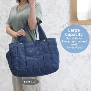 Close-up of navy blue quilted nylon tote bag in large size with reinforced handles