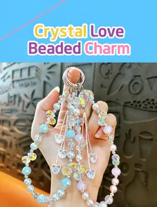 Detailed view of a heart beaded phone charm with crystal tassels and lustrous pearly beads