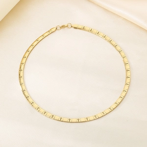 Detailed view of golden flat stainless steel necklace with engraved cross patterns