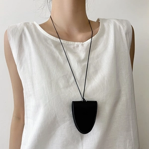 Détail du collier porte-lunettes en cuir noir montrant la texture et l'utilité pratique