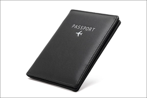 Macro view of black leather RFID passport holder featuring silver engraved aircraft icon