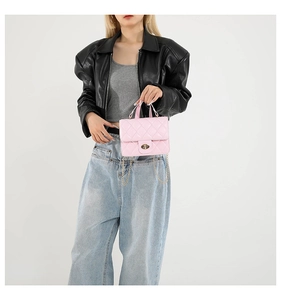 Detail of pink quilted handbag showing gold chain strap and metallic twist-lock closure