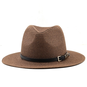 Detailed close-up of dark brown woven straw fedora with black leather band and gold buckle