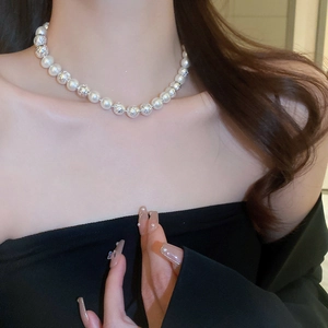 Elegant pearl and textured silver bead necklace worn by a model on the collarbone