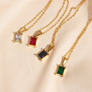 Détail de pendentifs en zircon carrés en quatre couleurs sur tissu de soie beige