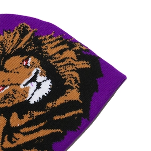 Close-up of purple knit beanie showing detailed texture and jacquard lion pattern