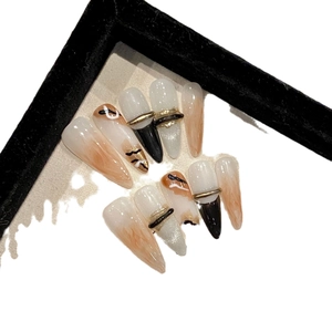 Brown stiletto press-on nails with marble patterns, silver glitter, and gold ring accents