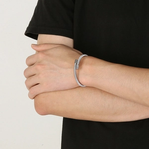 Detail of silver woven mesh bracelet with spring coil design and buckle on wrist