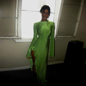 Détail d'une robe maxi vert herbe scintillante avec fente latérale haute et dos ouvert