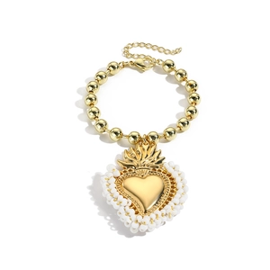 Detaillierte Nahaufnahme von goldenem Herz-Armband mit weißen Perlen und Karabinerverschluss