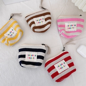 Detailed view of colorful striped canvas makeup bags with zippers and woven pull cords