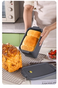 Silicone collapsible rectangular loaf pan with lid holding freshly baked toast in kitchen