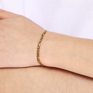 Close-up of golden Cuban link bracelet with geometric bars on a person wrist