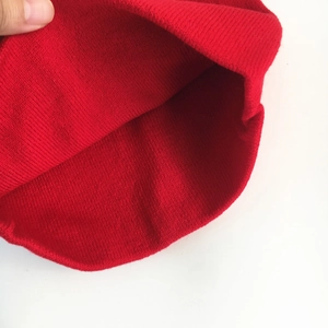 Detailed view of red knitted hat showing texture, elastic fabric and fine craftsmanship