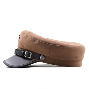 Détail de la casquette marin marron avec visière en cuir noir et insigne d'ancre en métal